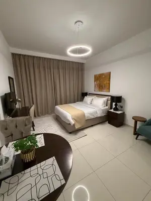 a bedroom with a bed and a couch and a table at Cove Luxe Holiday Home JVC in Dubai