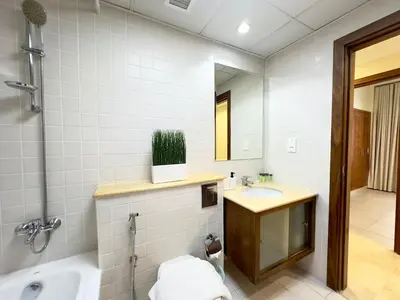 a bathroom with a sink and a tub and a mirror at Charming 2BR in Dubai Marina with Lake View in Dubai