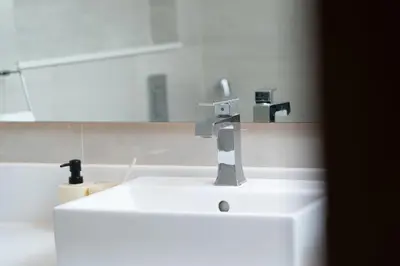 a bathroom sink with a faucet and a mirror at Luxury 2BR in Mada Residences - Walk to Dubai Mall in Dubai