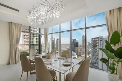 a dining room with a table and chairs and a large window at Luxury 2BR in Mada Residences - Walk to Dubai Mall in Dubai