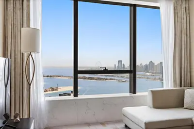 a living room with a large window with a view of the ocean at Luxury 1BR in The Palm Tower Near Nakheel Mall in Dubai