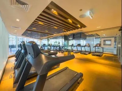 a gym with rows of treadmills in a building at Vogue Al Furjan Gemz by Danube near Ibn Battuta Mall, Three Bedroom plus Kids room Apartment with Balcony and Private Pool, Access to all amenities in Dubai