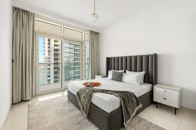 a bedroom with a large bed and a large window at 2BR Beachfront Retreat with Palm and Dubai Eye Views in Dubai