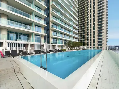 an empty swimming pool in front of a building at 2BR Beachfront Retreat with Palm and Dubai Eye Views in Dubai