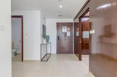 a hallway with two doors and a tile floor at Burj Khalifa View - 2 Bedroom apartment at The Residence 5, Downtown - Allsopp & Allsopp in Dubai