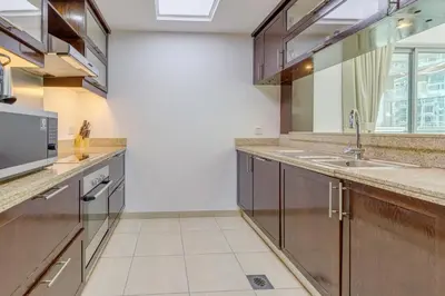 a kitchen with wooden cabinets and a sink at Burj Khalifa View - 2 Bedroom apartment at The Residence 5, Downtown - Allsopp & Allsopp in Dubai
