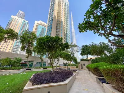 a park in the middle of a city with tall buildings at Burj Khalifa View - 2 Bedroom apartment at The Residence 5, Downtown - Allsopp & Allsopp in Dubai