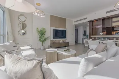 a living room with white furniture and a tv at Burj Khalifa View - 2 Bedroom apartment at The Residence 5, Downtown - Allsopp & Allsopp in Dubai