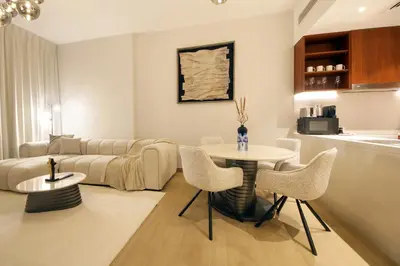a living room with a couch and a table and chairs at Stylish Apartment in Le Pont Jumeirah Near Beach in Dubai