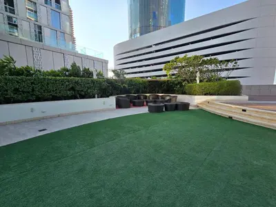 a green lawn in front of a building at Marina Sky Luxe Penthouse in Dubai