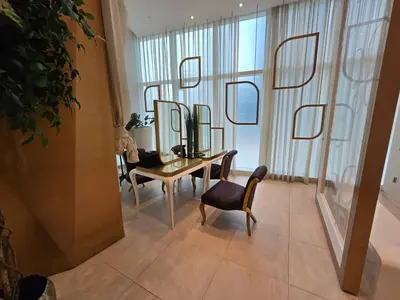 a room with a table and chairs and mirrors at Marina Sky Luxe Penthouse in Dubai