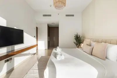 a living room with a white couch and a flat screen tv at Blissful Stays - Luxury Two Bedroom Apartment at ACT Tower 2, Boulevard, Burj Khalifa, Pool, Near Dubai Mall in Dubai