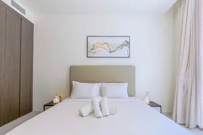 a bedroom with a bed with two pillows on it at TRPS - District One Residences, MBR - Brand New 3BR plus Maids, Lagoon View, Fully Furnished in Dubai