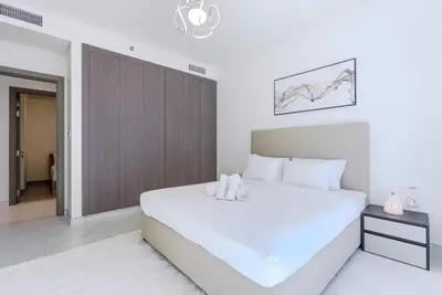 a bedroom with a large white bed with two stuffed animals on it at TRPS - District One Residences, MBR - Brand New 3BR plus Maids, Lagoon View, Fully Furnished in Dubai