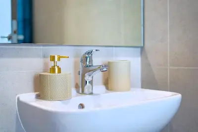 a bathroom sink with a faucet and two paper towels at TRPS - District One Residences, MBR - Brand New 3BR plus Maids, Lagoon View, Fully Furnished in Dubai