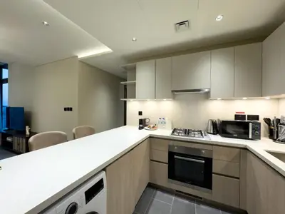a kitchen with white counter tops and a microwave at Werova-Cozy 2-Bedroom Apartment w Stunning Views in Dubai