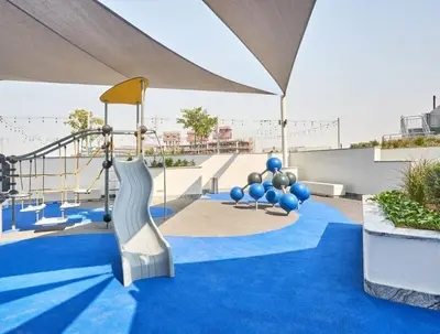 a playground with a slide on a blue carpet at Werova-Cozy 2-Bedroom Apartment w Stunning Views in Dubai