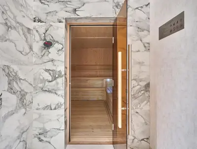 a bathroom with a walk in closet with marble walls at Werova-Cozy 2-Bedroom Apartment w Stunning Views in Dubai