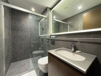 a bathroom with a sink and a toilet and a mirror at Werova-Cozy 2-Bedroom Apartment w Stunning Views in Dubai