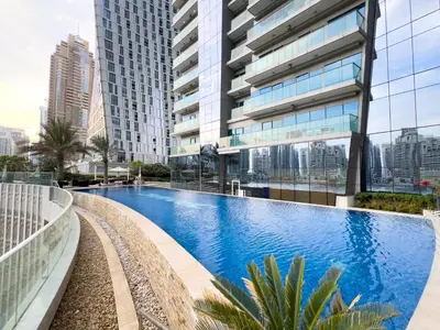 a swimming pool in front of a tall building at Luxury Fendi with Stunning Marina Views in Dubai