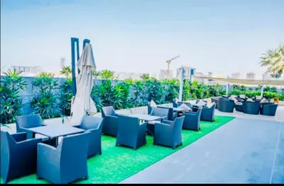 a patio with blue chairs and tables and an umbrella at Luxury Fendi with Stunning Marina Views in Dubai