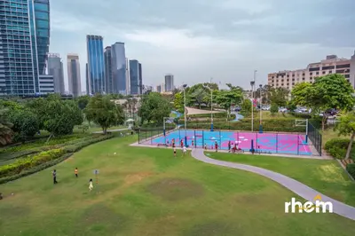 a park in a city with people walking around it at Brand New 2-BR Panoramic View - Near Marina & JBR in Dubai