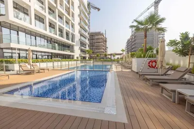 an image of a swimming pool in a building at Bright Studio with Pool Access - Azizi Riviera in Dubai