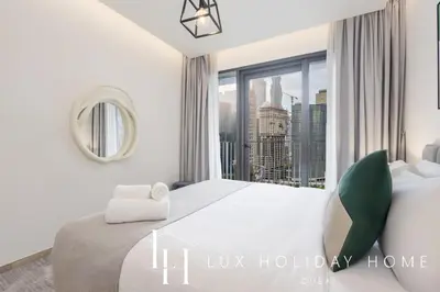 a bedroom with a large bed with a window at LUX The Business Bay Executive Suite in Dubai