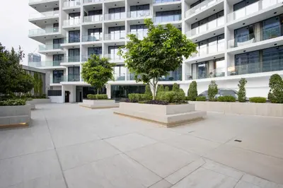 a courtyard in front of a building with a tree at Brand New 1B with Burj Khalifa View in Business Bay in Dubai
