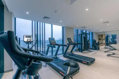 a gym with cardio equipment in a building with windows at Peaceful and Cozy Studio, Burj Khalifa View in Dubai