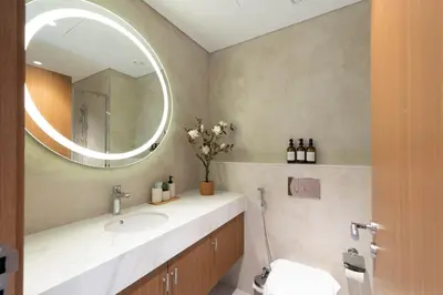 a bathroom with a sink and a mirror at Elegant Studio with Balcony & Pool in Dubai Studio City in Dubai