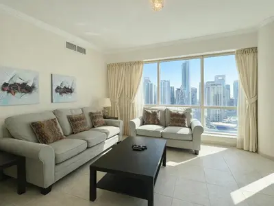 a living room with a couch and a table at Dream Shoma - 2R Serene Apt Direct Marina access in Dubai