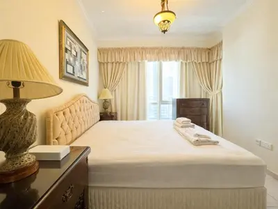 a bedroom with a bed with a lamp and a window at Dream Shoma - 2R Serene Apt Direct Marina access in Dubai