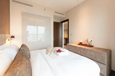 a bedroom with a large bed with white sheets at Luxury 1BR Retreat near DIFC & Downtown Dubai in Dubai