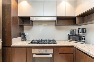 a kitchen with a stove and a microwave at PVH - Creek Residences South T3 - Harbourfront 2BR in Dubai