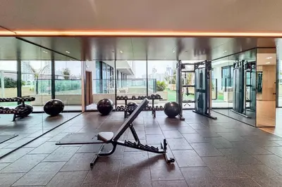 a gym with cardio equipment in a building with glass at PVH - Pristine 1BR Minutes to Circle Mall - Binghatti Amber in Dubai