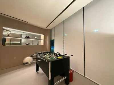 a room with a foosball table in front of a wall at Luxury 1BR Apartment with Private Pool & Gym Access in Dubai