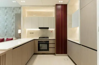 a kitchen with white cabinets and a stove top oven at Modern 1BR Apartment with Private Pool in JVC in Dubai