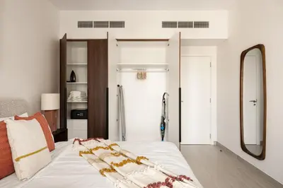 a bedroom with a white bed and a mirror at Designer 1BR with Skyline View in MJL - Near Iconic Burj Al in Dubai