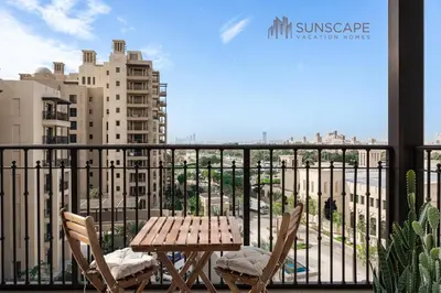 a table and chairs on a balcony with a view of a city at Designer 1BR with Skyline View in MJL - Near Iconic Burj Al in Dubai