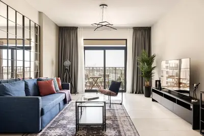a living room with a blue couch and a table at Designer 1BR with Skyline View in MJL - Near Iconic Burj Al in Dubai