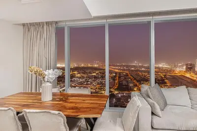 a living room with a table and a large window at Stylish 4BR with Burj & Fountain View, Dubai Mall Connection in Dubai