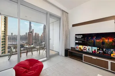 a living room with a flat screen tv and a large window at Stylish 4BR with Burj & Fountain View, Dubai Mall Connection in Dubai