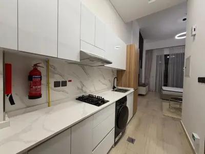 a kitchen with white cabinets and a stove top oven at Chic Studio Living Elysee III by Pantheon in Dubai