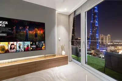 a living room with a flat screen tv on a wall at 4BR Penthouse Feel Featuring Stunning Burj And Fountain View in Dubai