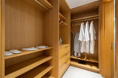 a walk in closet with wooden cabinets and shelves at 4BR Penthouse Feel Featuring Stunning Burj And Fountain View in Dubai