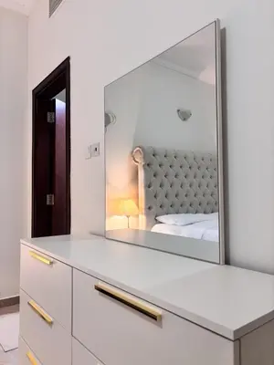 a bedroom with a large mirror on a dresser at Miraclema Stays Al Barsha 1 in Dubai