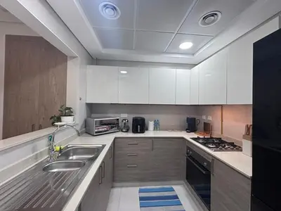a kitchen with white cabinets and stainless steel appliances at High-Floor 1BR Escape - The Bay Rooftop Pool in Dubai
