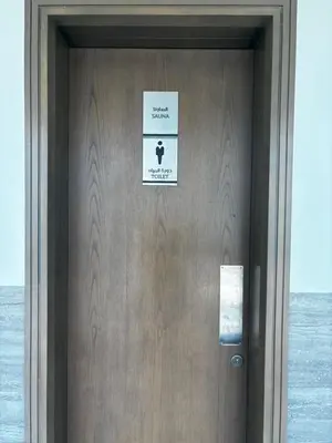 a door with a sign on it next to the ocean at High-Floor 1BR Escape - The Bay Rooftop Pool in Dubai