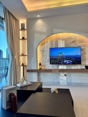 a living room with a flat screen tv on a wall at Luxury 2BR, Burj Khalifa View, Fully equipped, Top Amenities in Dubai